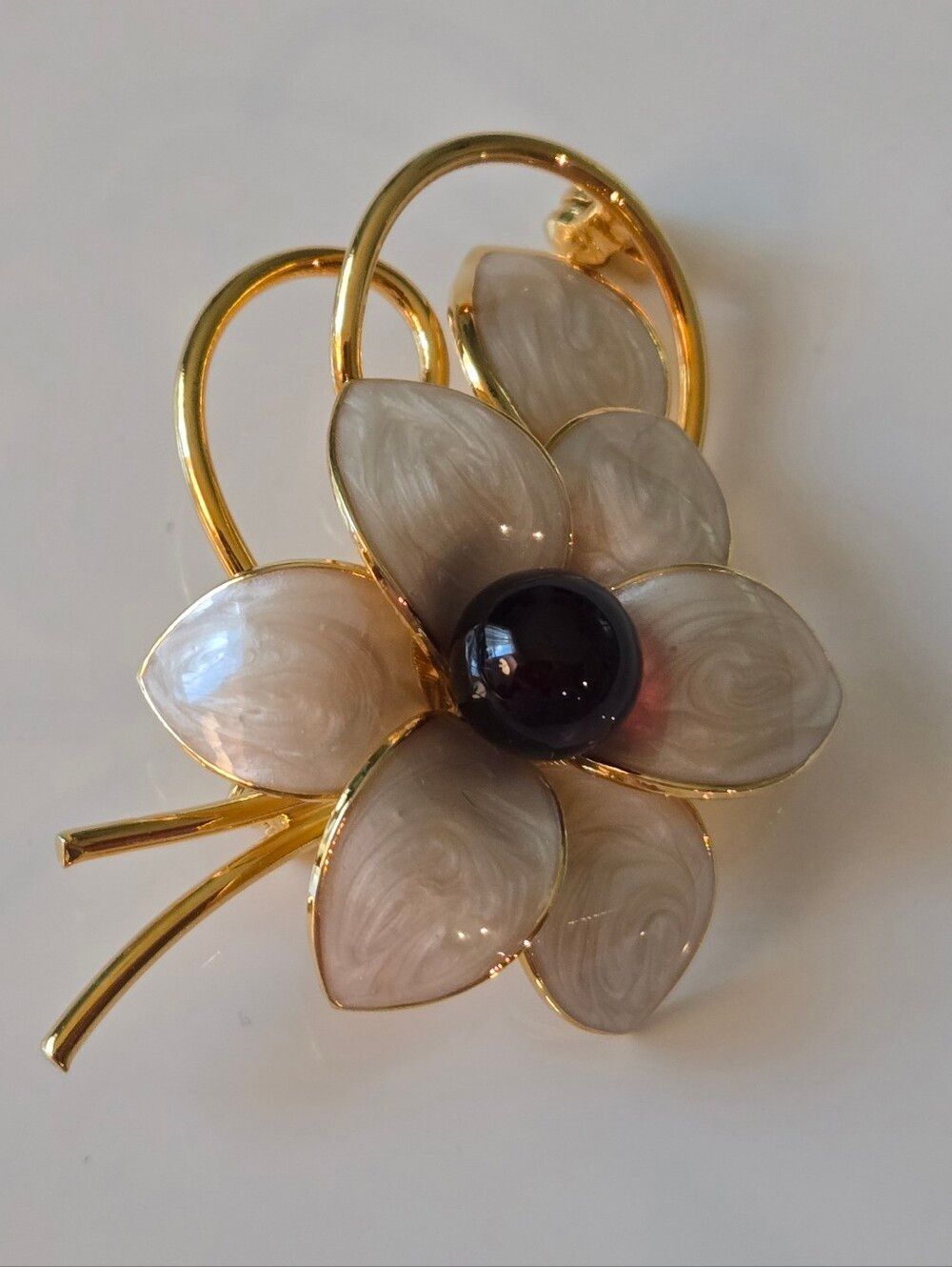Gold-Tone Floral Brooch with Cream Enamel Petals and Black Center.